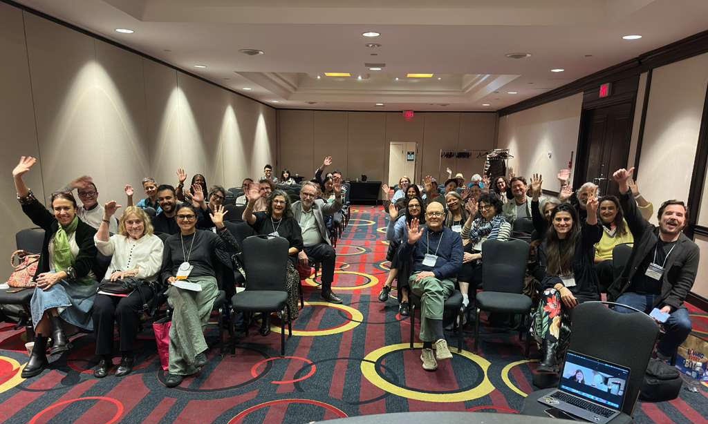 The crowd at the Candidates Panel waving hello in a photo for Bita